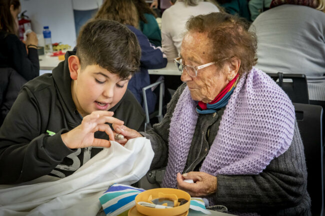 Abuela y niño cosiendo exposición Pendiebtes de un hilo Famsi