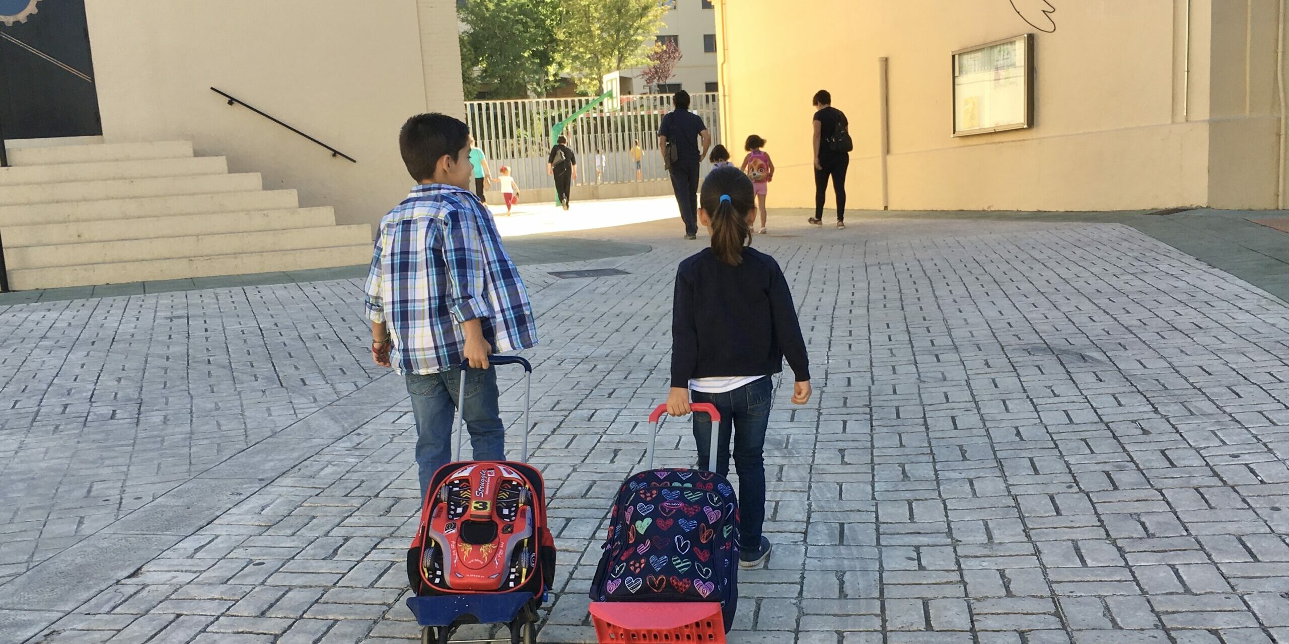 Escolares entrando al cole con mochila