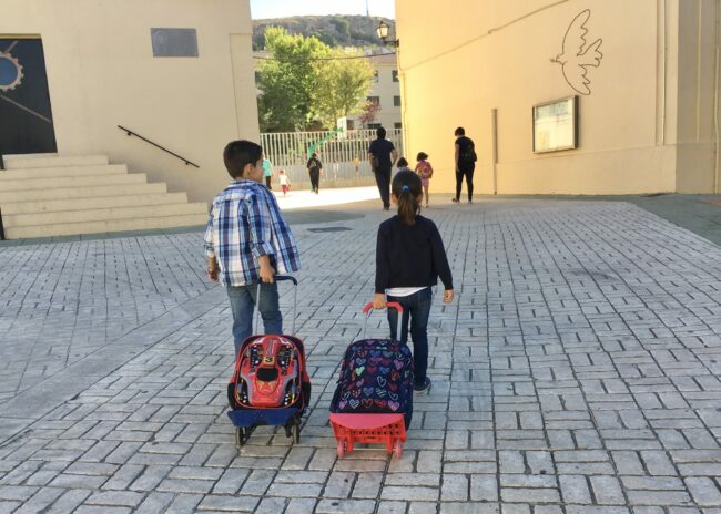 Escolares entrando al cole con mochila